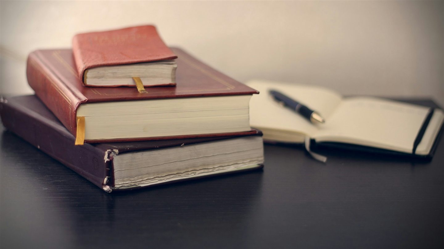 Legal books and an open notebook arranged on a quiet office desk.