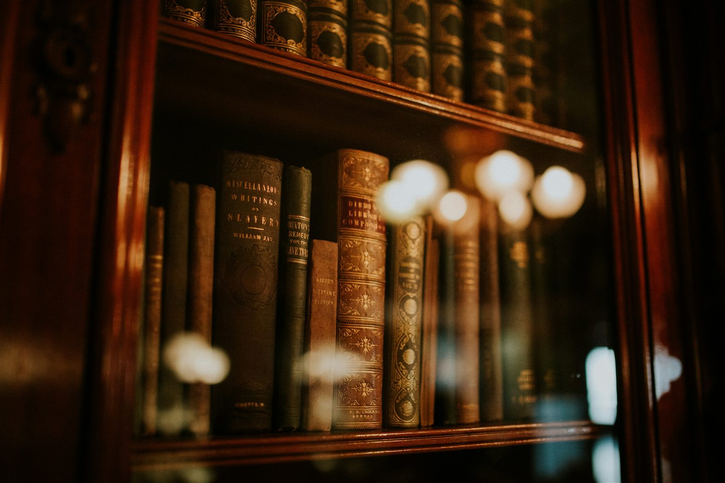 Warm law library shelves with historic legal books behind glass.